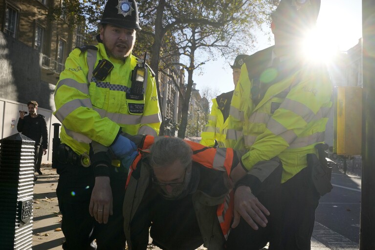 Police arrests protesters of the climate campaigners group Just Stop Oil in London, Thursday, Nov. 23, 2023. (AP Photo/Frank Augstein)